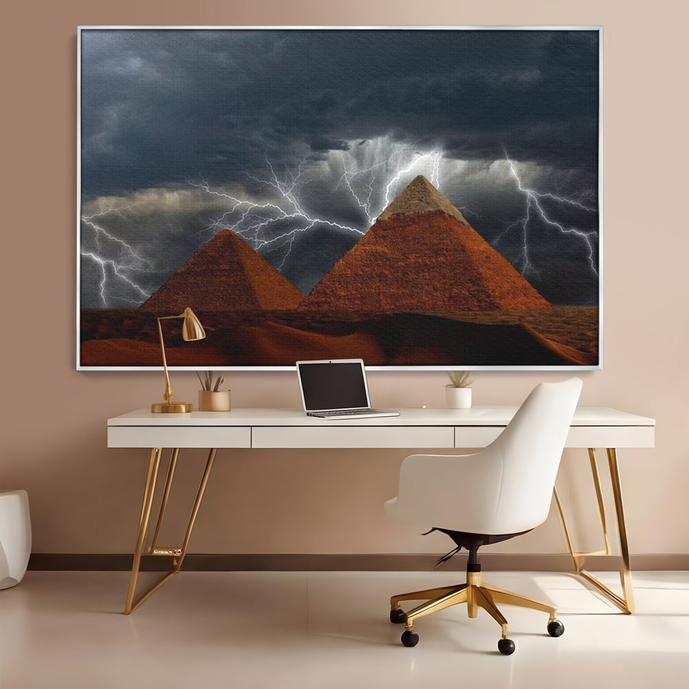 Tablou canvas cu ilustratie cu piramide si fulgere, in rama de aluminiu argintiu, pe perete intr-un birou
